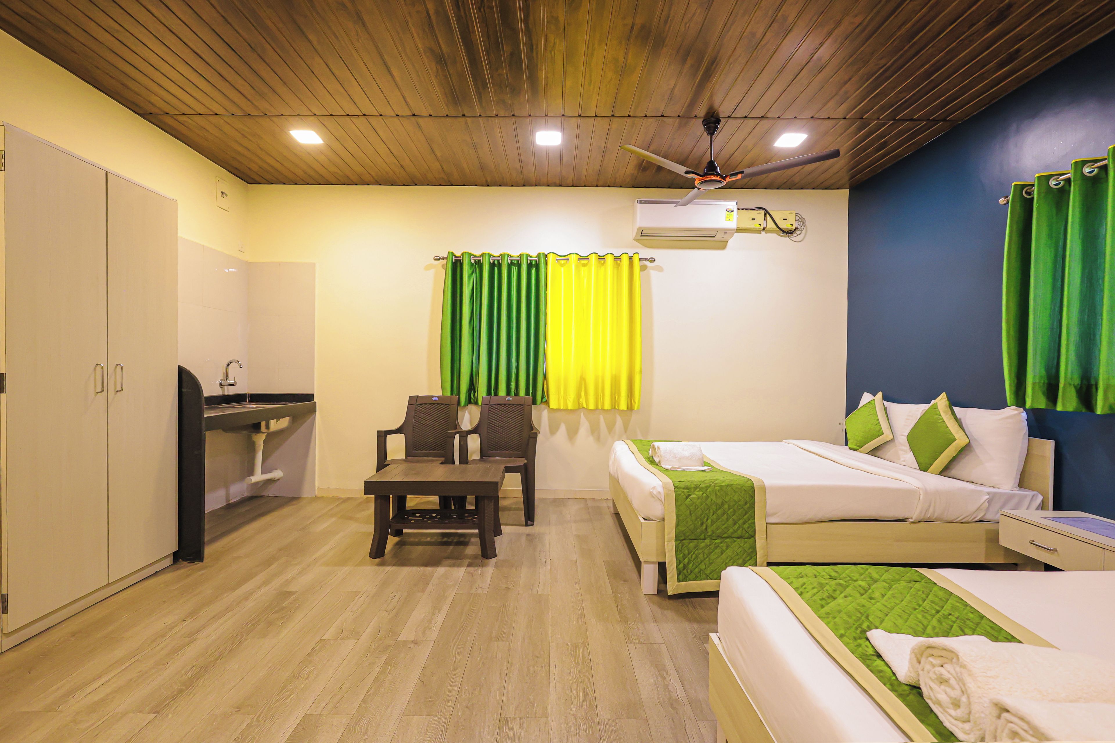A hotel room with a bed, a desk, a chair, and a wardrobe.