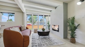 Relax in this stylish living room with a high ceiling, large windows, and a cozy sofa.