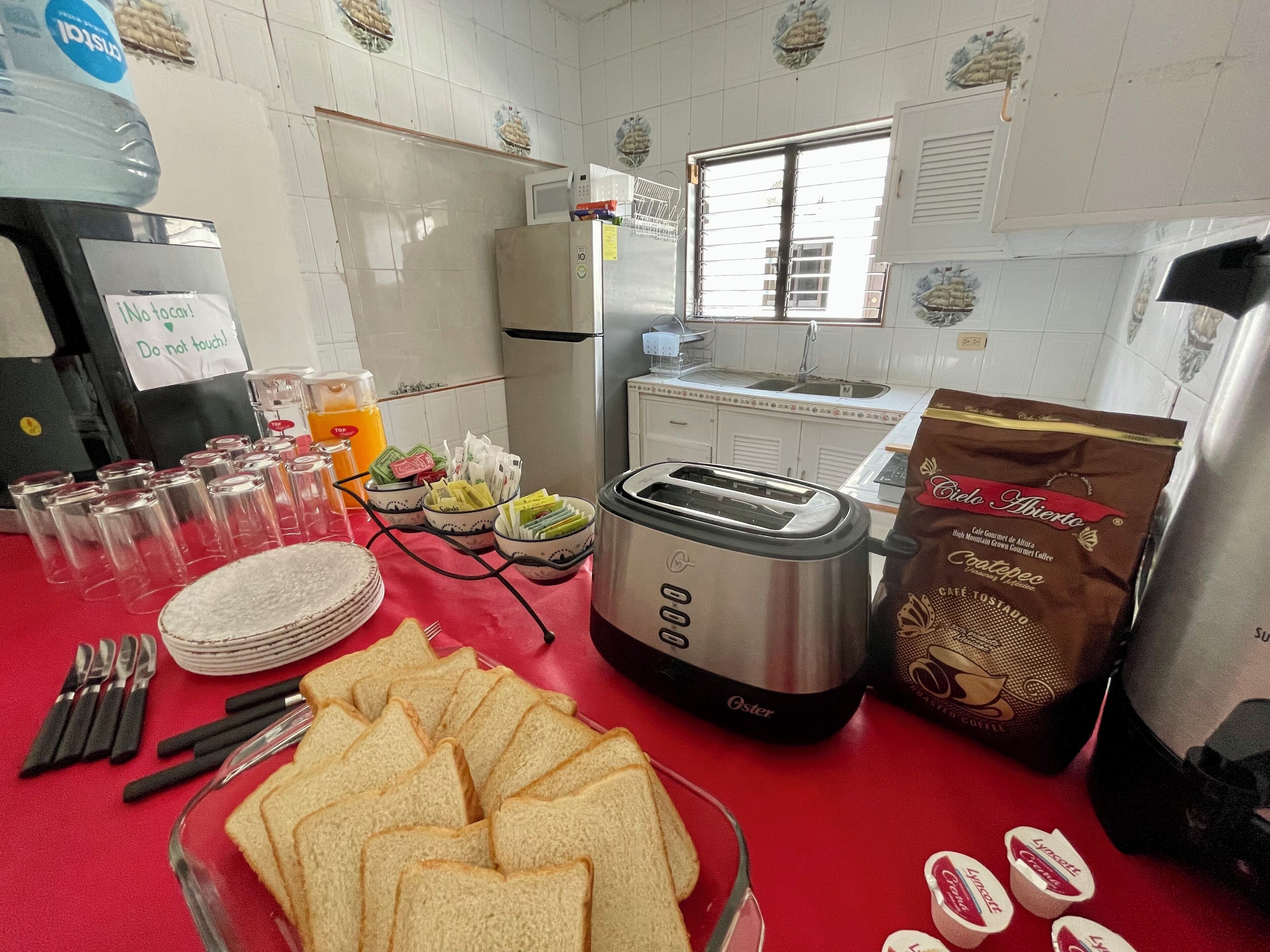 A kitchen with a toaster, a bag of coffee, and a glass of orange juice on the counter.