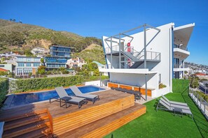 A modern building with a pool, outdoor seating, and a view of the surrounding area. - Luxury Sea Point Pad with Ocean balcony views (Cape Town)