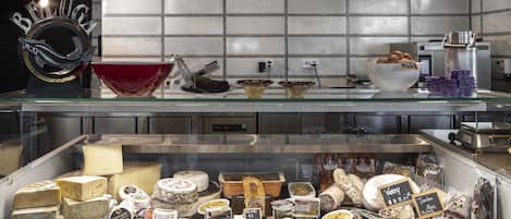 A cheese display with various types of cheese and related products.