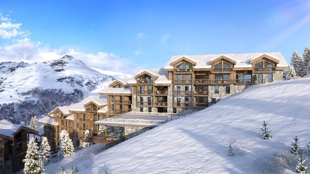 A multi-story lodge with a stone facade and wooden balconies, set against a snowy mountain backdrop. - Higalik Hotel (Les Belleville)