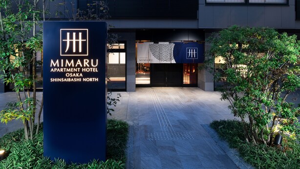 The exterior of the Mimaru Apartment Hotel in Shinsaibashi North, featuring a modern facade, a welcoming entrance, and surrounding greenery. - MIMARU Osaka Shinsaibashi North (Osaka)