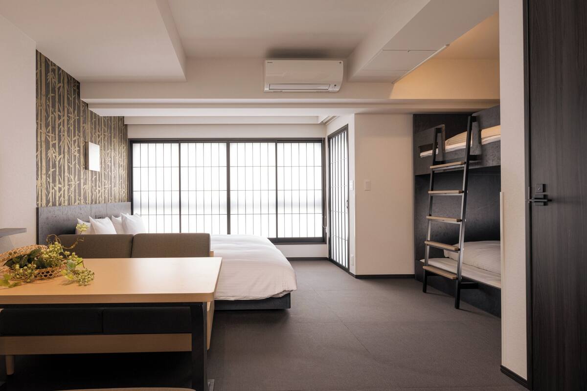Una habitación de hotel moderna con cama, sofá, escritorio y televisión.