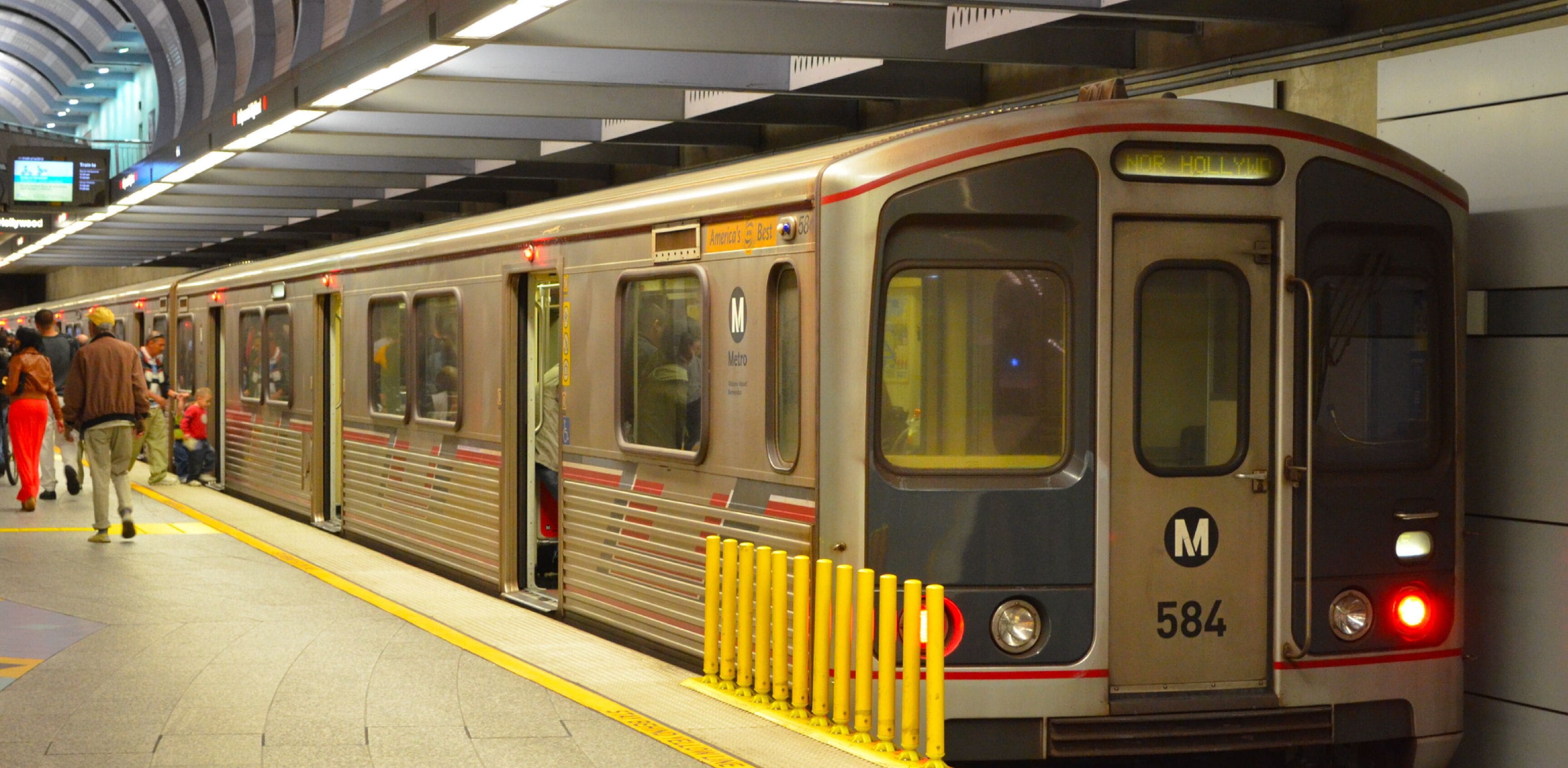Un tren de metro en una estación con pasajeros esperando.