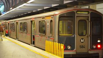 Un tren de metro en una estación con pasajeros esperando.