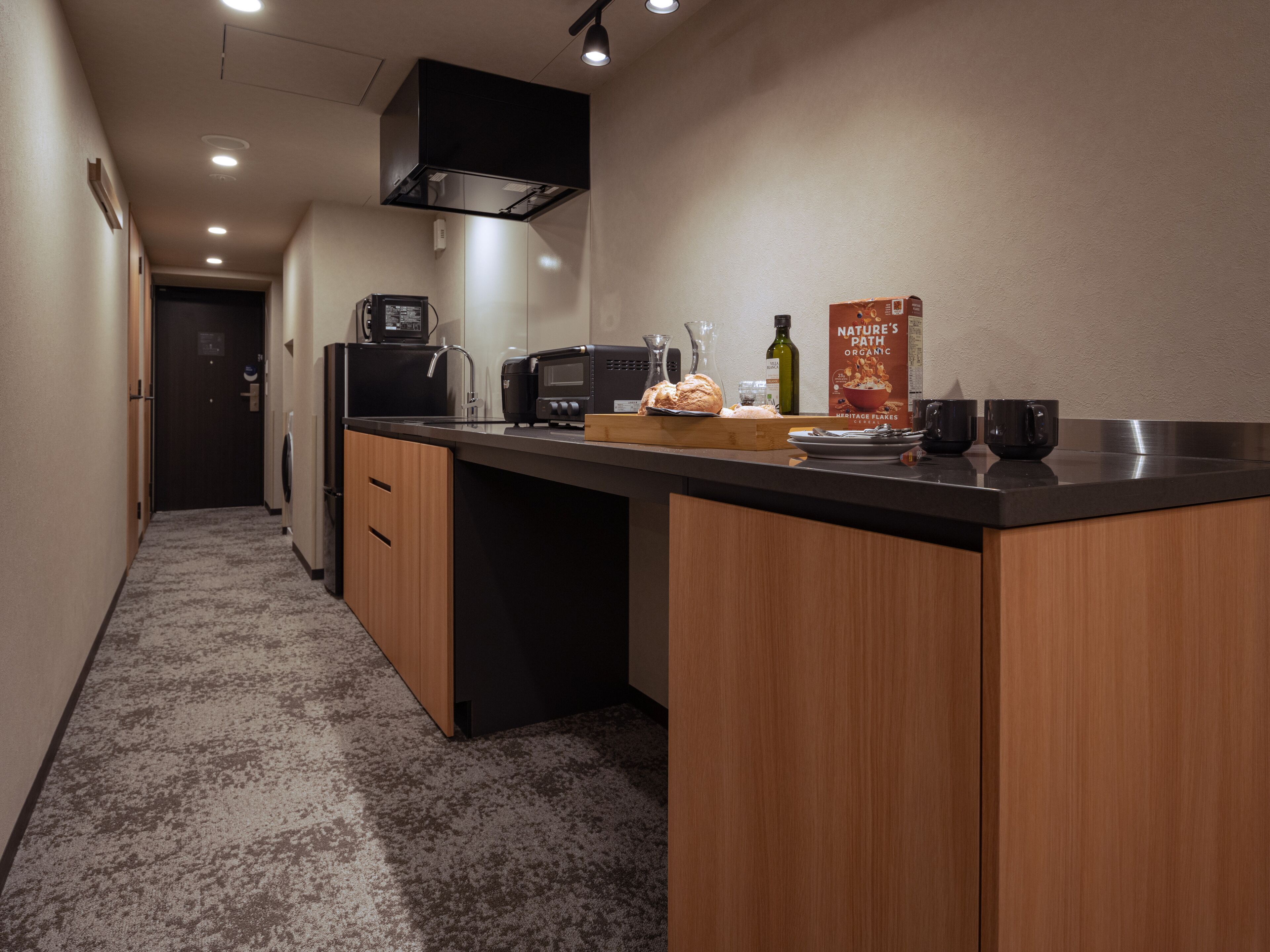 A modern kitchen with a central island, built-in appliances, and a countertop with a bread box, toaster, and coffee maker.