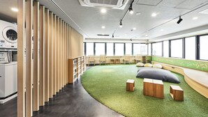 A modern office space with a curved seating area, wooden partitions, and large windows.