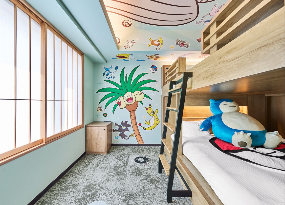 A room with a bunk bed, a small cabinet, and a wall mural featuring cartoon characters.
