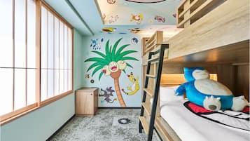 A room with a bunk bed, a small cabinet, and a wall mural featuring cartoon characters.
