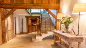 A wooden staircase with a handrail, a wooden bench with a vase of flowers, and a lamp. - Detached 500m2 Farmhouse with Yoga Studio, Hot Tub and Sauna (Samoëns)