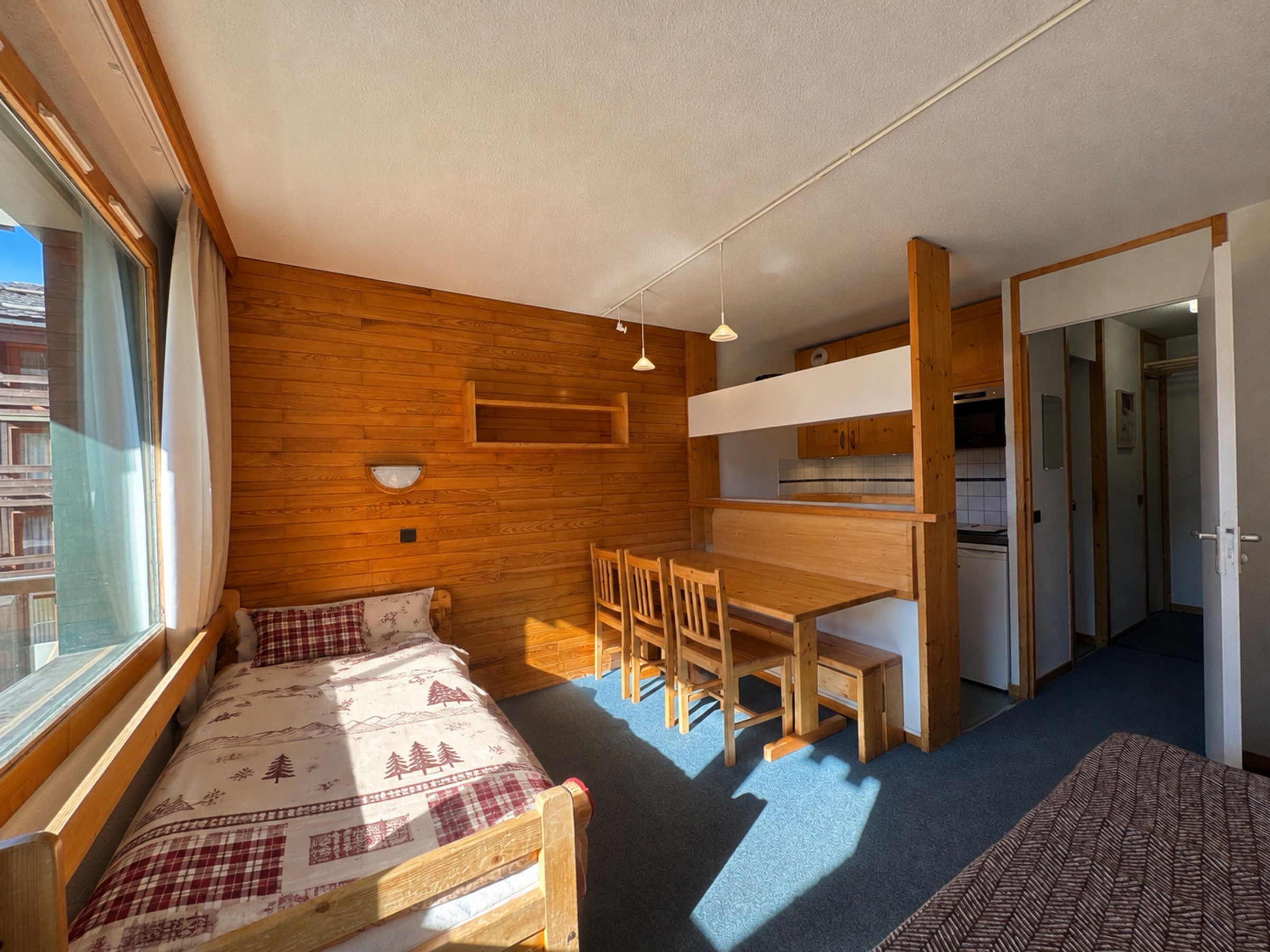 A compact room with a bed, a desk, and a chair.