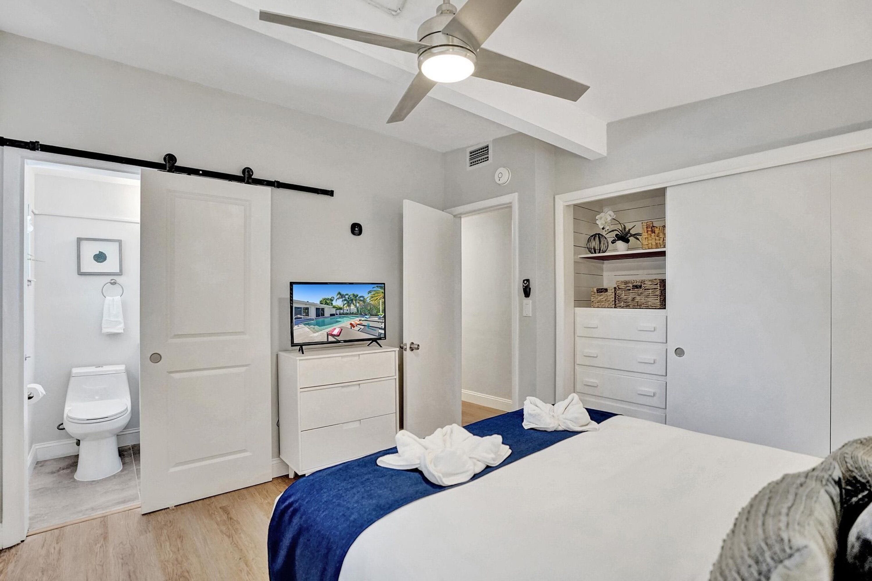 A hotel room with a bed, a television, a wardrobe, and a bathroom.