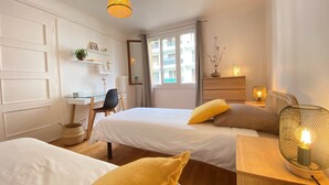 A hotel room with two beds, a desk, and a window. - Renovated T3 Apt with Balcony & Parking in Annecy Center (Annecy)