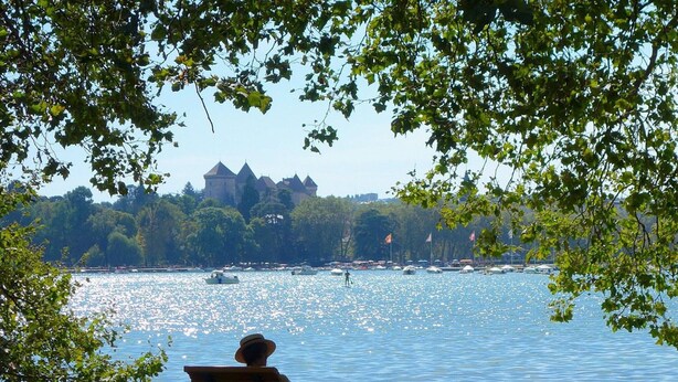 A bench overlooking a lake with boats and a castle in the background. - Renovated T3 Apt with Balcony & Parking in Annecy Center (Annecy)