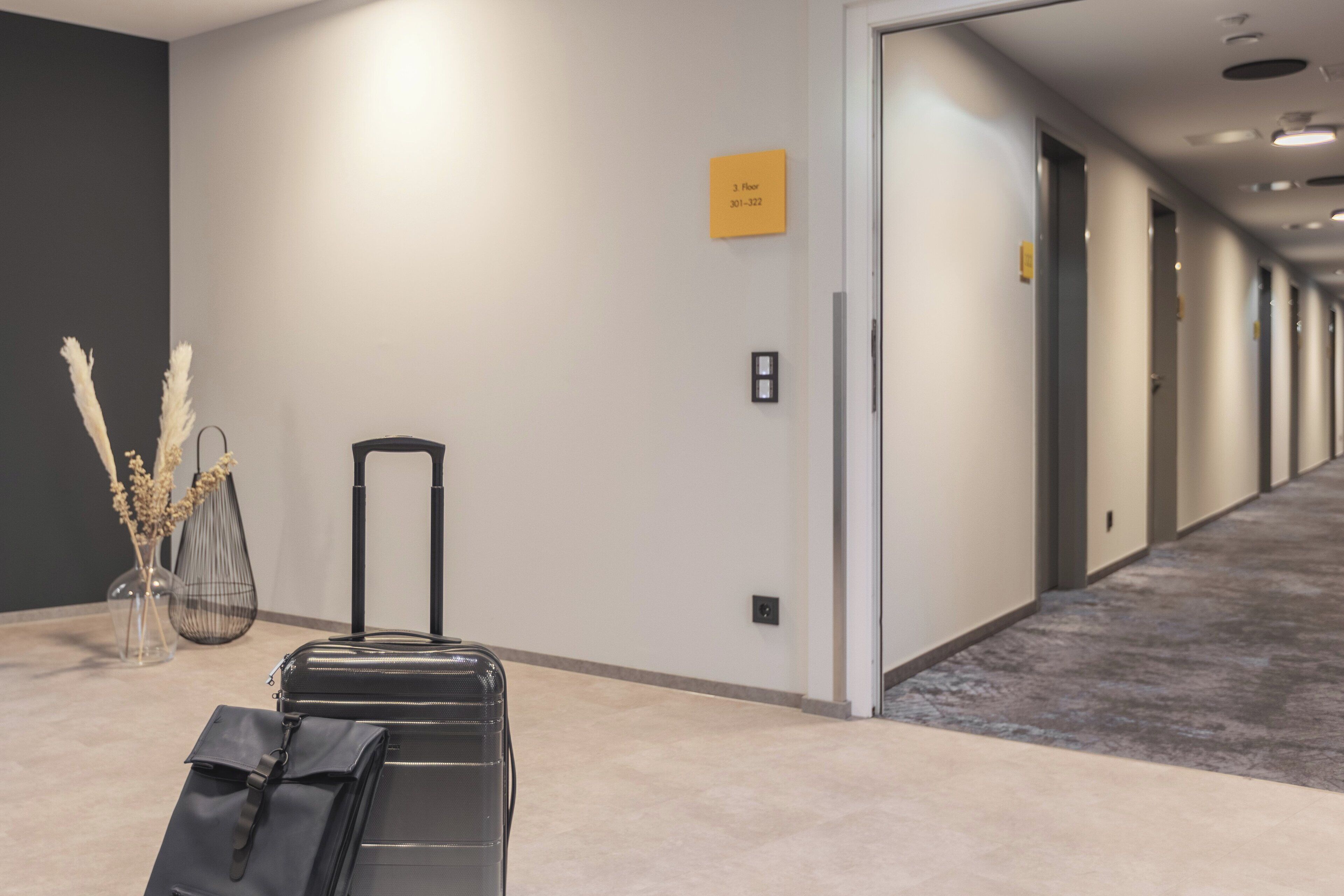A hotel corridor with a sign indicating the 3rd floor and room number 301-322.
