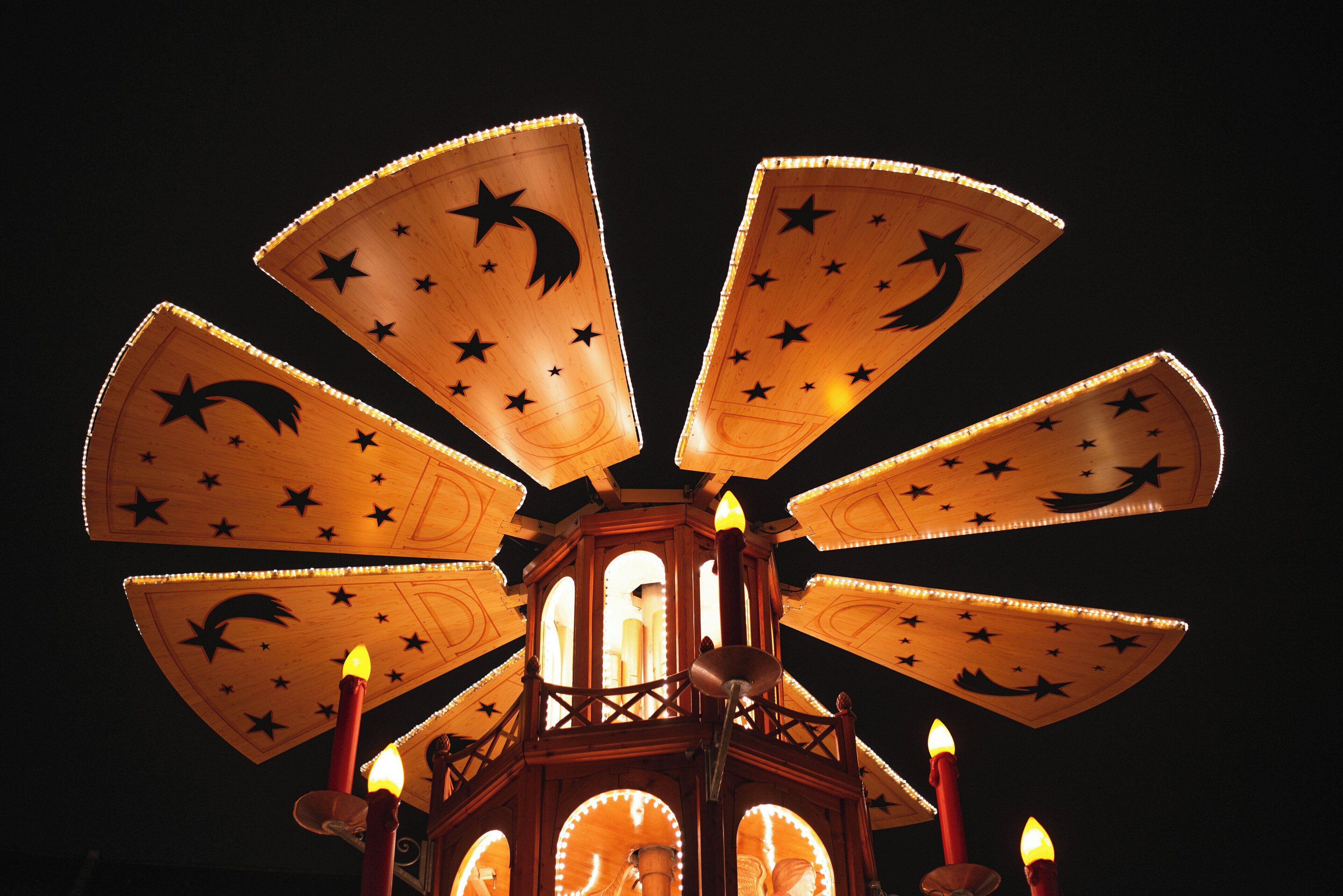 Un carrusel con diseños iluminados de estrella y luna creciente.