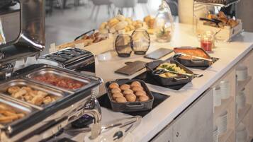 A buffet with various food items and utensils.