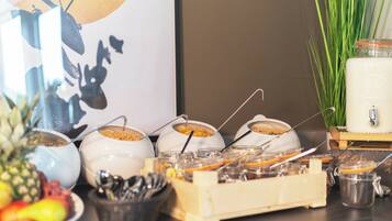 A breakfast buffet with various food items and utensils.
