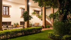A courtyard with a staircase, potted plants, and outdoor seating. - Hanuwant Niwas (Jodhpur)