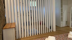 A room with a white partition, a wooden cabinet, and a patterned rug.
