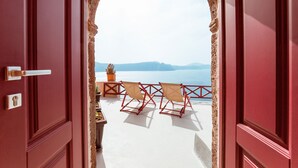 A red door leading to a terrace with a view of the sea and mountains. - Terracotta Cave House (1) (Santorini)