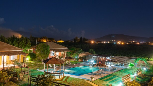 A resort with a swimming pool, lounge chairs, and a gazebo.