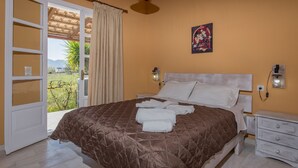 A bedroom with a bed, a nightstand, a wall-mounted lamp, and a window with curtains.