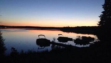 Un llac tranquil al capvespre amb vaixells amarrats.