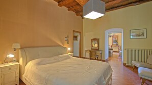 A bedroom with a large bed, bedside lamps, a dresser, a mirror, and a radiator. - Inviting 6-bed House in Brindisi (Brindisi)
