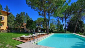 A rectangular swimming pool with a stone deck and metal railings, surrounded by a grassy lawn and trees. - Inviting 6-bed House in Brindisi (Brindisi)