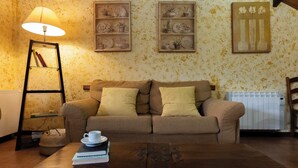 Un salon chaleureux avec un canapé, une table basse, une lampe et des étagères décoratives.