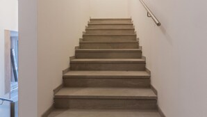 A staircase with a handrail, leading to an upper floor.