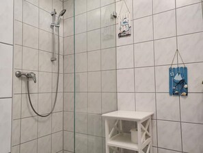 Regadera, secadora de cabello, papel de baño 