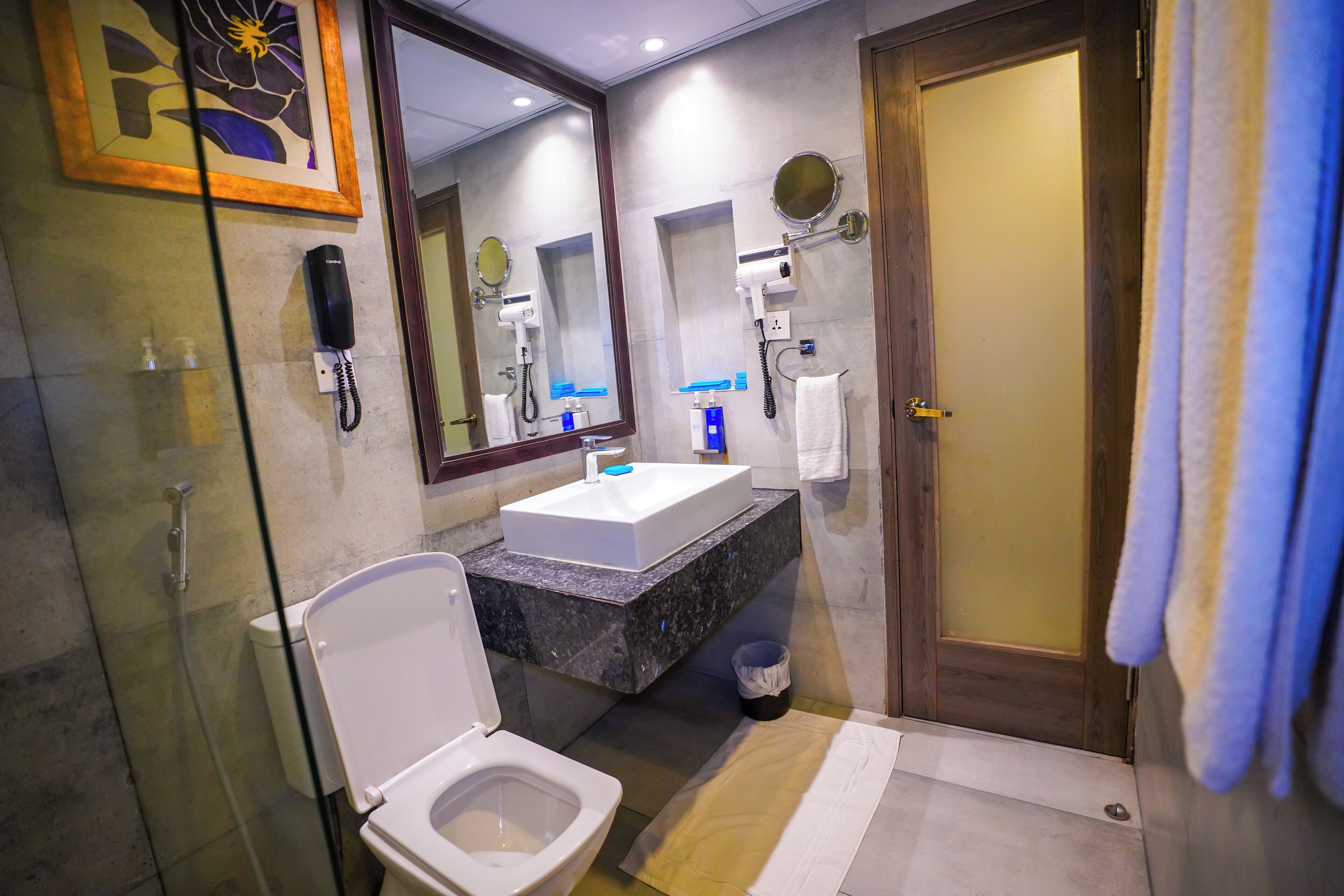 A bathroom with a toilet, sink, mirror, and shower.