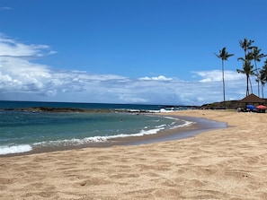 Enjoy a serene beach experience with calm waters and gentle waves lapping at the shore.