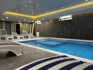Innendørsbasseng og solsenger
