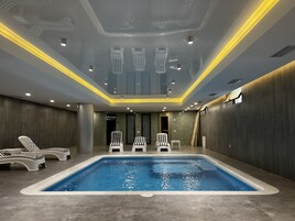 Una piscina techada, sillones reclinables de piscina