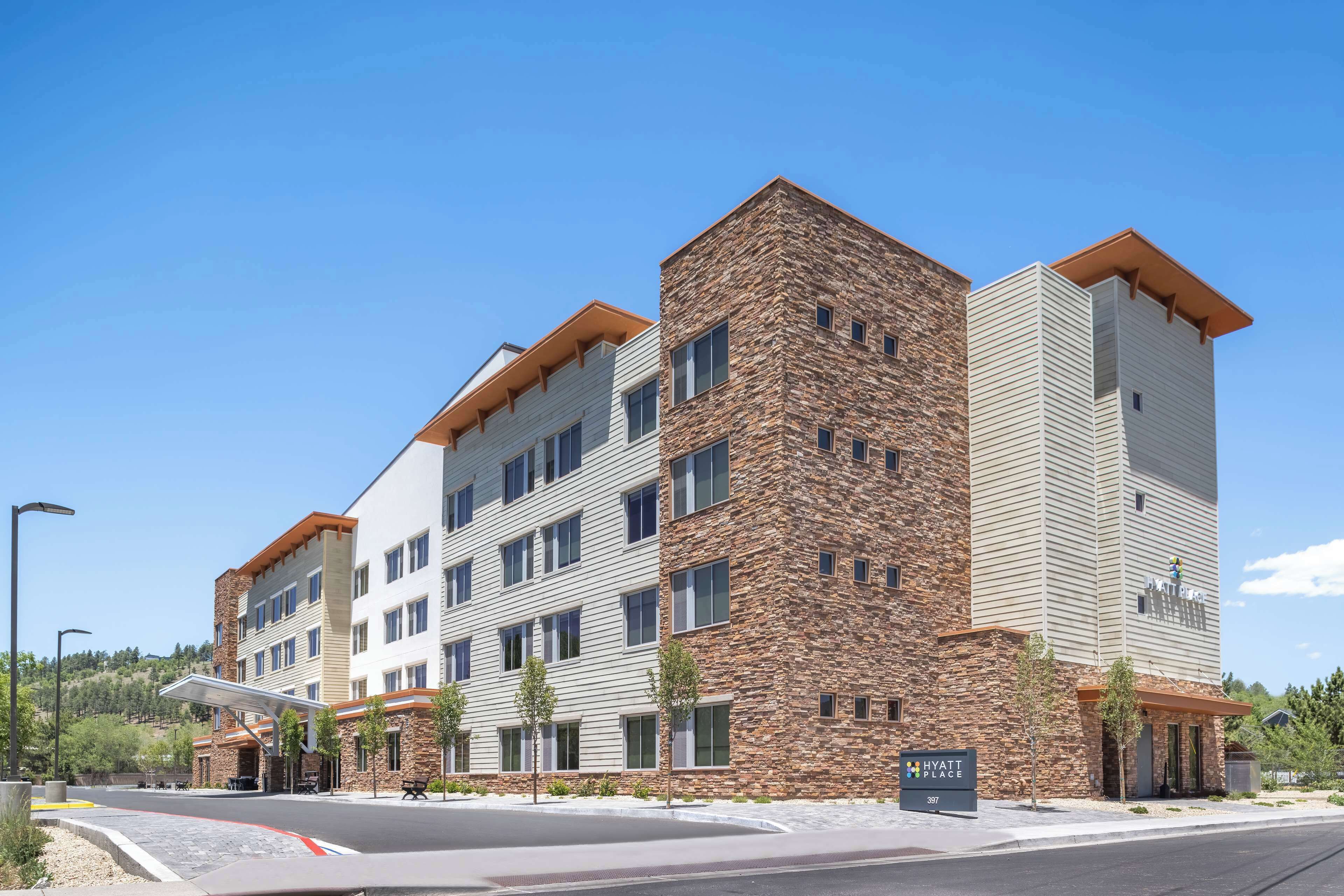 A multi-story hotel with a stone facade and a flat roof.