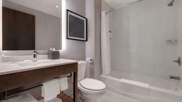 Un baño moderno con un lavamanos, inodoro y bañera blancos.
