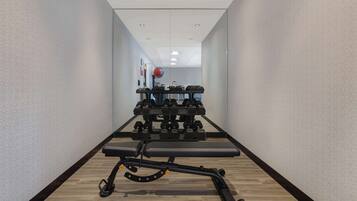 A gym with a bench, dumbbells, and a medicine ball.