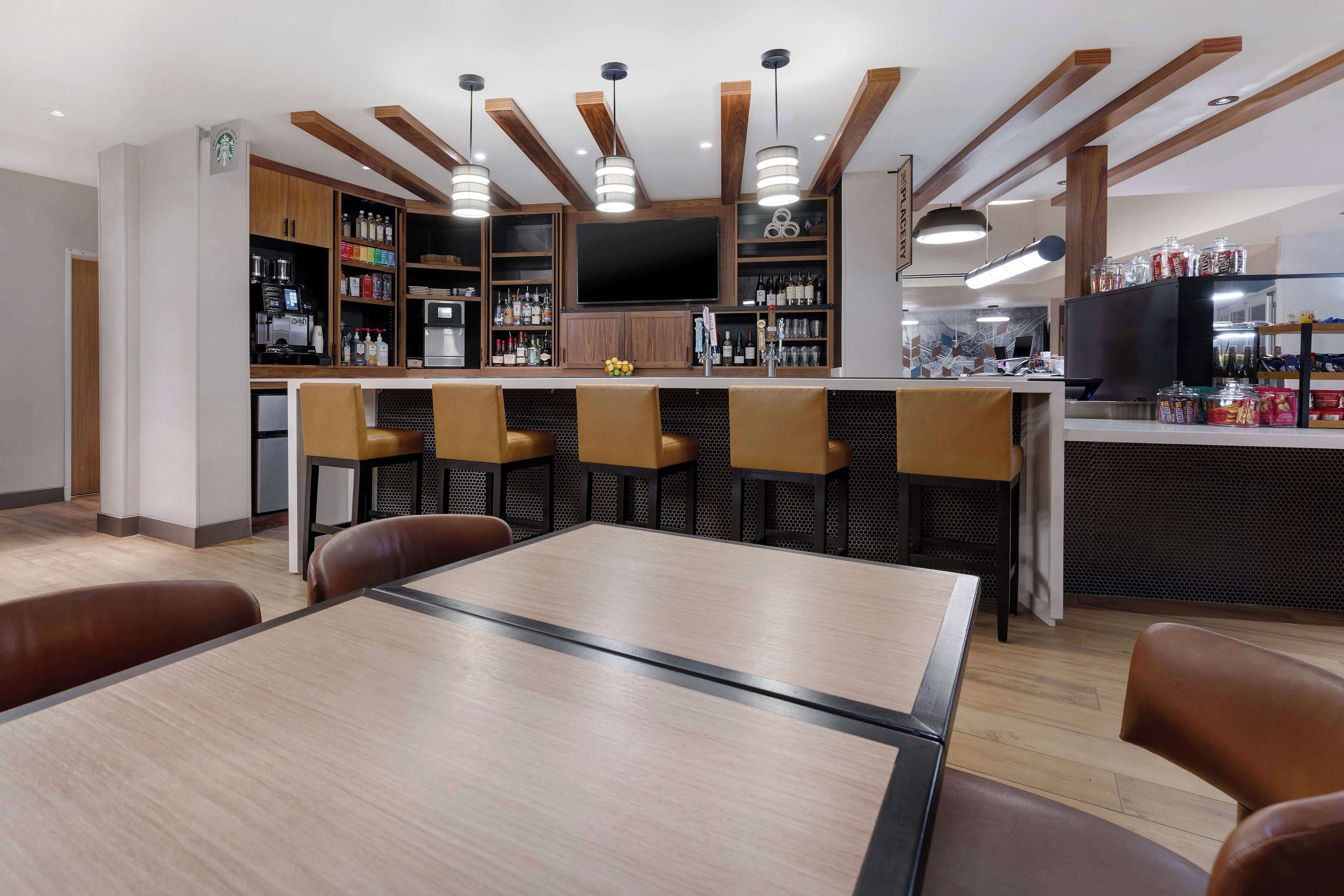 Eine moderne Küche mit Bar, Holzbalken und einem großen Flachbildfernseher.