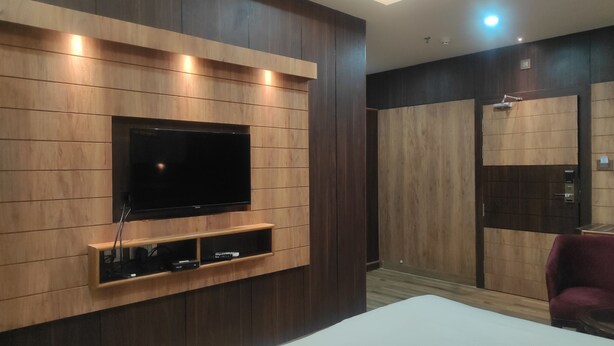 Una habitación moderna con televisión integrada, paneles de madera y un mueble bajo para entretenimiento.
