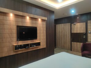 A modern room with a built-in TV, wooden paneling, and a small entertainment unit. - Hotel Aavas Inn (Tezpur)