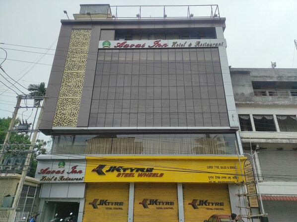 A building with a sign for 'Avas Inn Hotel & Restaurant' on the upper floor.