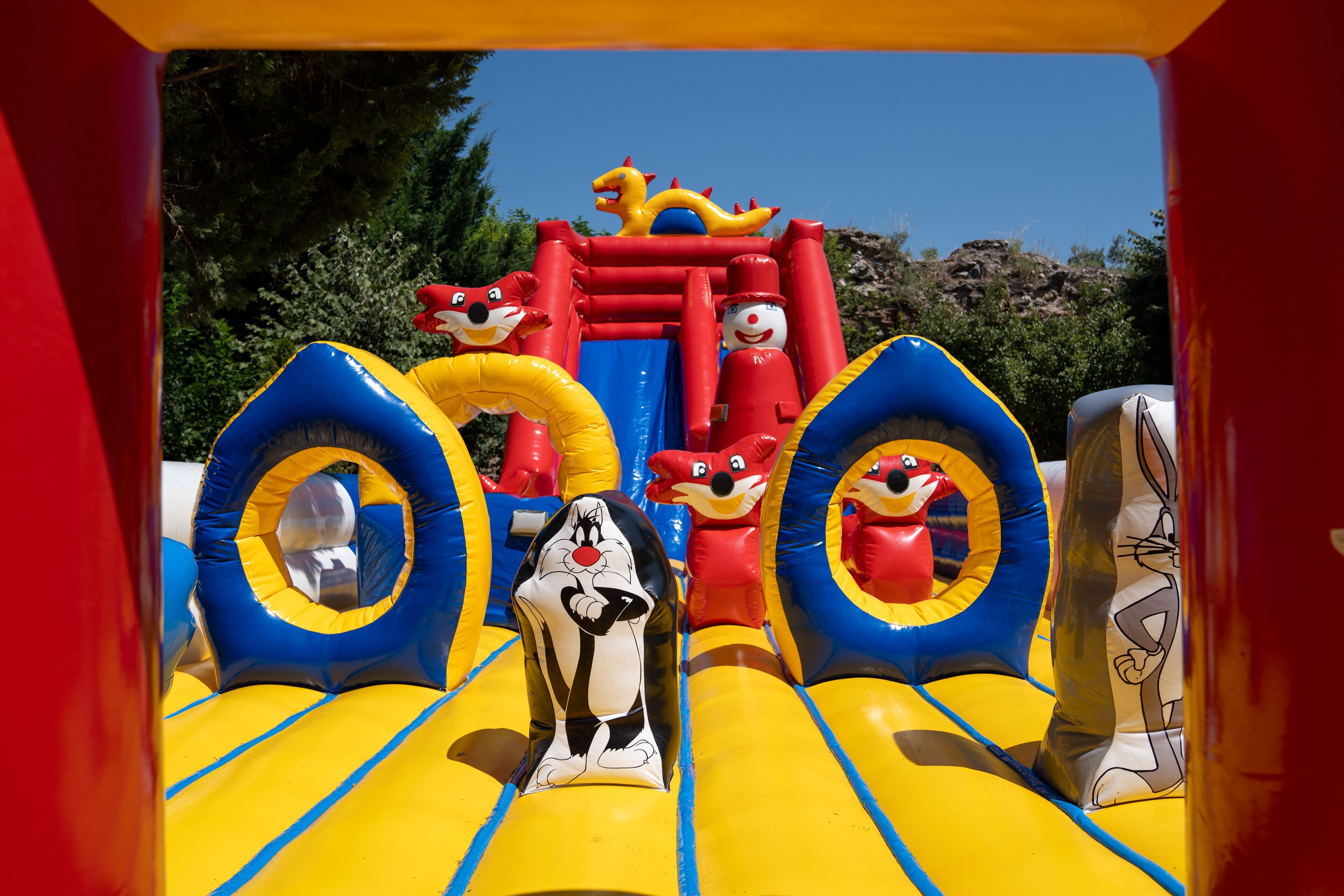 An inflatable play area with cartoon characters and slides.