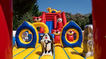 An inflatable play area with cartoon characters and slides.