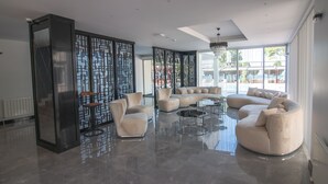A spacious living room with a large sectional sofa, a coffee table, and a decorative screen. - LAKE LİFE HOTEL (Iznik)