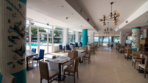 A spacious restaurant with high ceilings, large windows, and a view of the sea. - LAKE LİFE HOTEL (Iznik)