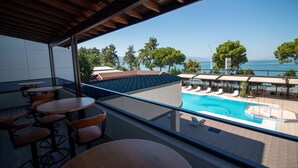 A balcony with a pool view, outdoor seating, and a clear view of the sea. - LAKE LİFE HOTEL (Iznik)